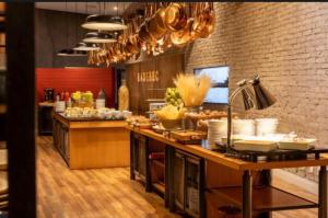 a kitchen with a counter with food on it at Radisson V Olimpia in São Paulo
