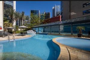 a large swimming pool in the middle of a city at Radisson V Olimpia in São Paulo