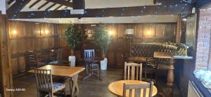 a restaurant with wooden walls and tables and chairs at The Crewe Arms Hotel in Crewe +7 photos