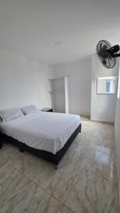 a bedroom with a white bed and a fan at Bambú Alojamiento in Carmen de Apicalá +21 photos