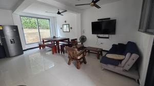 a living room with a tv and a table and chairs at Bambú Alojamiento in Carmen de Apicalá