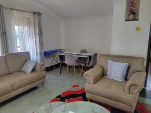 a living room with two couches and a table at Gee homestay Kakamega in Kakamega