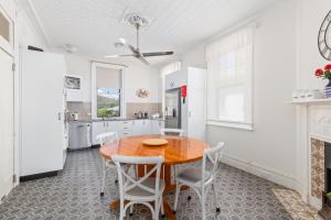 a kitchen with a wooden table and white walls at Tall Timbers Motel in Dungog