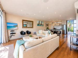 a living room with a couch and a table at The Sands - Villa 28 - Stay Waiheke in Onetangi