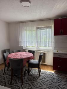 a dining room with a table and chairs and a window at XXL apartman Free parking in Visoko