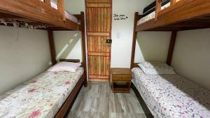 two beds in a small room with two beds at Casa Velha Hospedagem Jacuípe in Camaçari