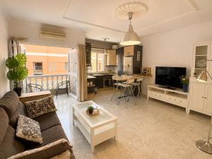 a living room with a couch and a tv and a kitchen at Roca Mogán in Puerto de Mogán
