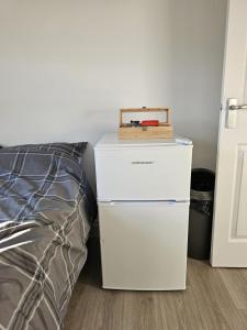 a white refrigerator next to a bed in a room at Modern Fully Contained En-Suite Room With Kitchen in Sidcup