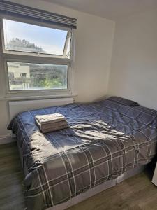 a bed in a room with a large window at Modern Fully Contained En-Suite Room With Kitchen in Sidcup