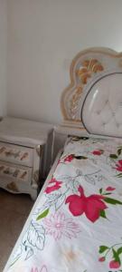 a bedroom with a bed with a floral bedspread at City Homes in Makurdu