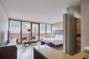 a hotel room with a bed and a large window at Mercure Bogota BH Zona Financiera in Bogotá