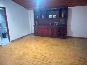 an empty living room with a wooden floor and a counter at Hostal Castillo in Filandia