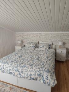 a bedroom with a bed with a blue and white comforter at The Cherry Tree Place in Góis