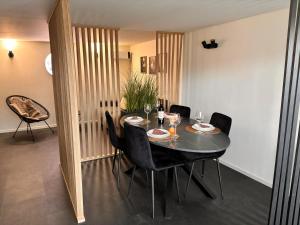 a dining room with a table and black chairs at Hidden Garden in Braine-le-Château