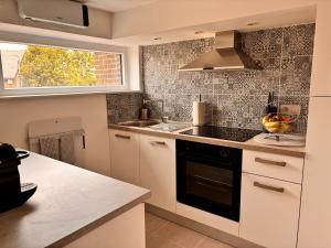 a kitchen with a sink and a stove top oven at Hidden Garden in Braine-le-Château