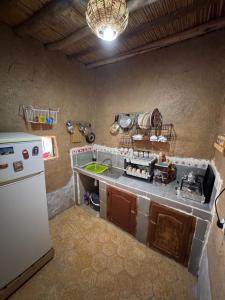 a kitchen with a white refrigerator and a counter top at Guest House For Rent Merzane in Merzane