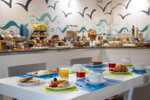 a table with plates of food and drinks at Hotel Casa Yvorio in Terracina
