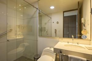 a bathroom with a sink and a glass shower at Hotel bh El Poblado in Medellín