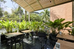 a patio with tables and chairs and plants at Hotel bh El Poblado in Medellín