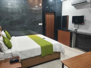 a bedroom with a bed and a tv in a room at HoTEL MADHAVI PRIME in Guntūr