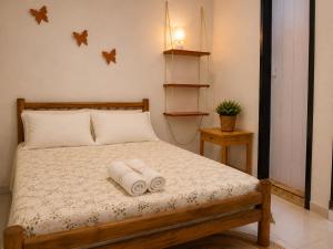 a bedroom with a bed with two towels on it at Ammonite Hostel - Itacaré in Itacaré