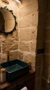 a blue sink in a bathroom with a stone wall at Alies Konağı in Mardin