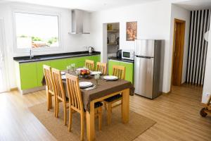 a kitchen with a table with chairs and a refrigerator at Casa da Tapada - Grupo Casas Vale do Lima in Ponte de Lima