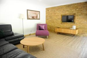 a living room with a couch and a purple chair at Casa da Tapada - Grupo Casas Vale do Lima in Ponte de Lima +19 photos