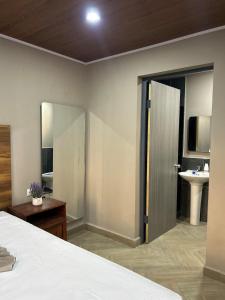 a bedroom with a bed and a bathroom with a sink at Boaco Suites - Apartments in Boaco