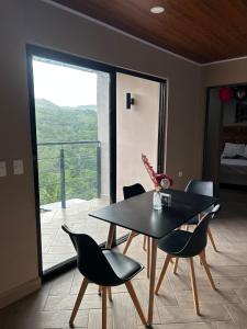 a dining room with a table and chairs and a balcony at Boaco Suites - Apartments in Boaco