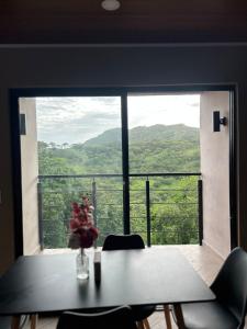 a table and chairs in front of a large window at Boaco Suites - Apartments in Boaco