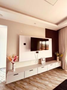 a living room with a large tv on the wall at Excutive suites in Kyebando