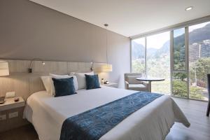a bedroom with a large bed and a large window at Hotel bh Bicentenario in Bogotá