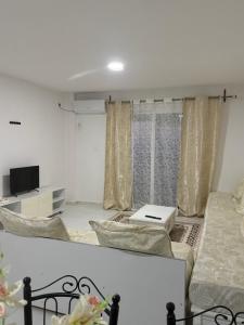 a living room with a bed and a tv at Résidence assia in Jijel