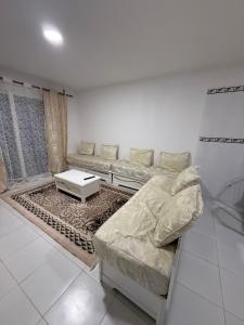 a white room with a bed and a table at Résidence assia in Jijel