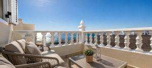 a balcony with chairs and a cross on a railing at Verde Mar, vive el oceano en primera linea in La Santa