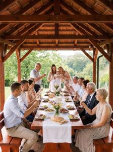 a group of people sitting around a long table at Srce Baranje in Podolje