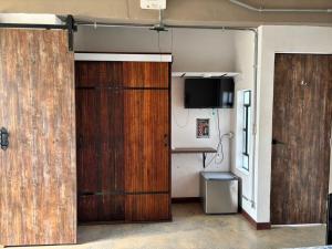 a room with two wooden doors and a television at La Curva in Cali