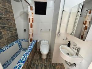 a bathroom with a toilet and a sink and a tub at La Curva in Cali +43 photos