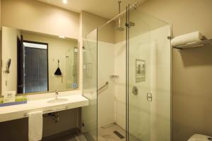 a bathroom with a glass shower and a sink at Hotel bh Usaquén in Bogotá