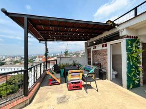 a patio with a pergola and chairs on a balcony at La Curva in Cali