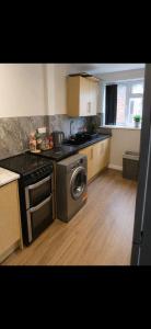 a kitchen with a stove and a washing machine at Hunters lodge in Blackpool