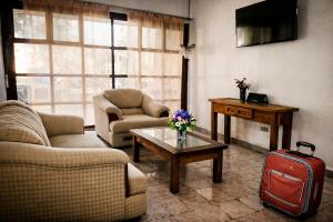 a living room with a couch and a table with a suitcase at HOTEL OASIS Matehuala in Matehuala