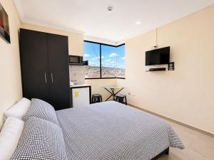 a bedroom with a bed and a large window at Suitesecu Rentals Cuenca in Cuenca