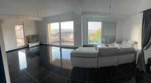 a living room with a white couch and a tv at Villa Pazar na dlanu in Novi Pazar