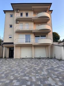 a building with two balconies and two garage doors at Villa Pazar na dlanu in Novi Pazar