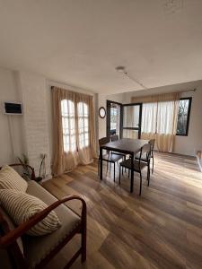 a living room with a table and chairs and a couch at Casa Colibrì Mendiolaza in Villa Allende