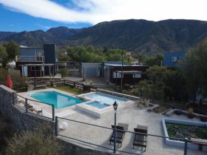 a swimming pool with mountains in the background at Terrazas de la Quinta - Cabañas de Montaña in Mendoza