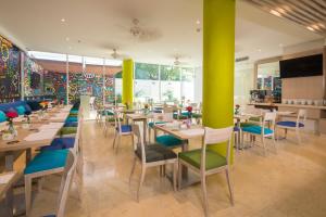 a restaurant with tables and chairs and colorful walls at bh Barranquilla in Barranquilla