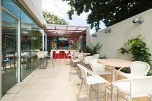 an outdoor patio with tables and chairs and a bar at bh Barranquilla in Barranquilla